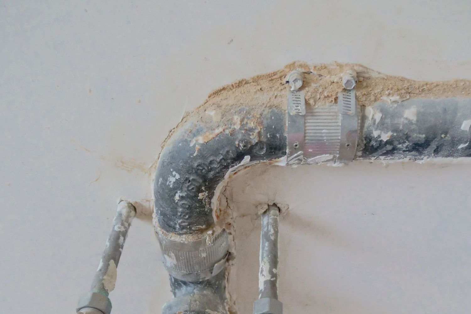 Tubería antigua de galvanizado a la vista en una pared abierta